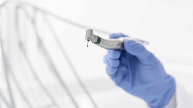 Zbliżenie ręki dentysty trzymającej wiertarkę dentystyczną