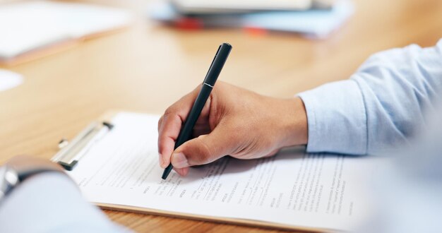 Zbliżenie ręki i podpisu na tablicę w biurze do pisania na formularzu prawnym zgodność lub wniosek Osoba adwokat lub dokument przez czytanie informacji lub umowę przez papiery kontraktowe na biurku