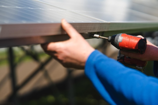 Zbliżenie ręki inżyniera, który dokręca śruby paneli słonecznych