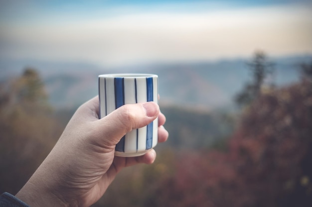 Zdjęcie zbliżenie ręki trzymającej drinka na niewyraźnym tle