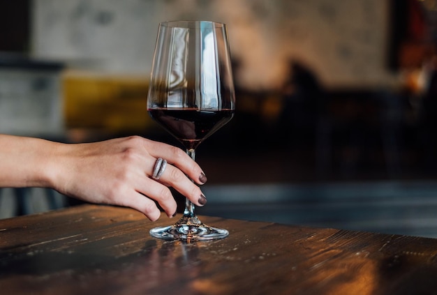Zbliżenie ręki trzymającej drinka na stole