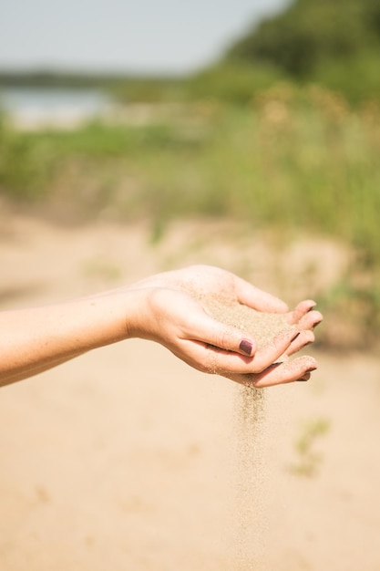 Zdjęcie zbliżenie ręki trzymającej laskę na piasku