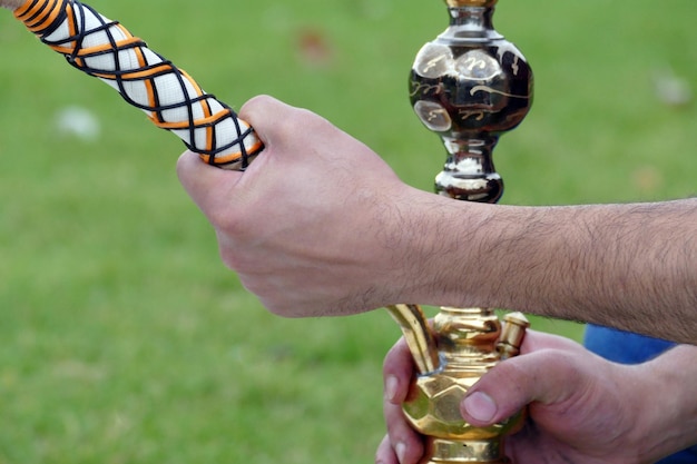 Zdjęcie zbliżenie ręki trzymającej shisha na polu