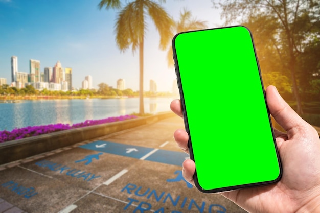 Zbliżenie ręki trzymającej telefon komórkowy w mieście