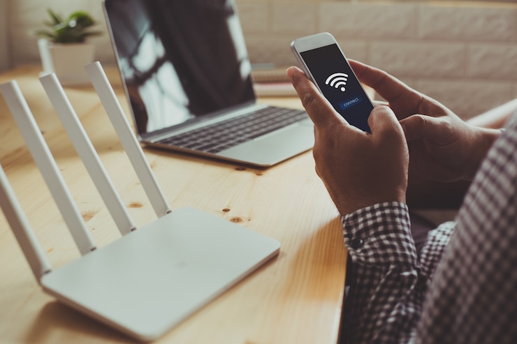 Zdjęcie zbliżenie routera wifi i człowieka za pomocą smartfona
