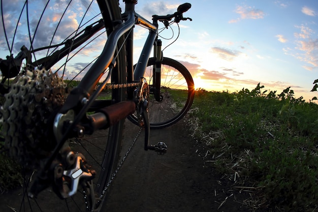 Zbliżenie roweru na szlaku o zachodzie słońca