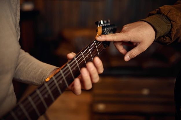 Zbliżenie rozmazane ręka mężczyzna muzyk grający na gitarze. Nauczyciel i uczeń na lekcji muzyki