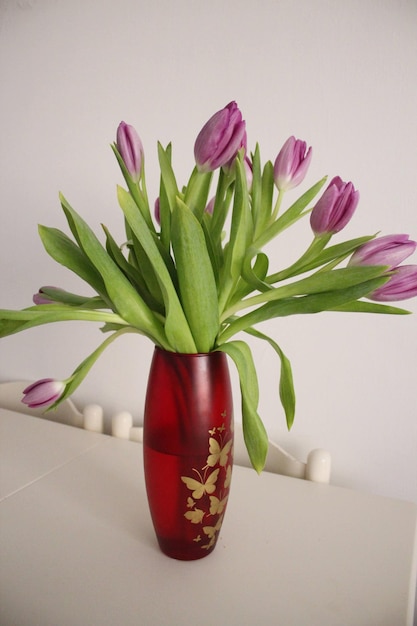 Zdjęcie zbliżenie różowego wazonu z kwiatami na stole