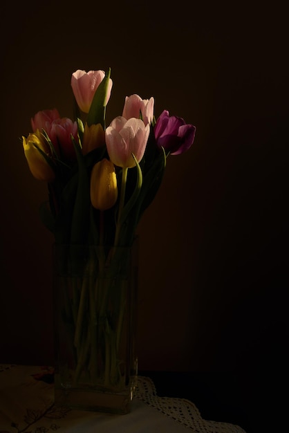Zdjęcie zbliżenie różowych tulipanów w wazonie na czarnym tle