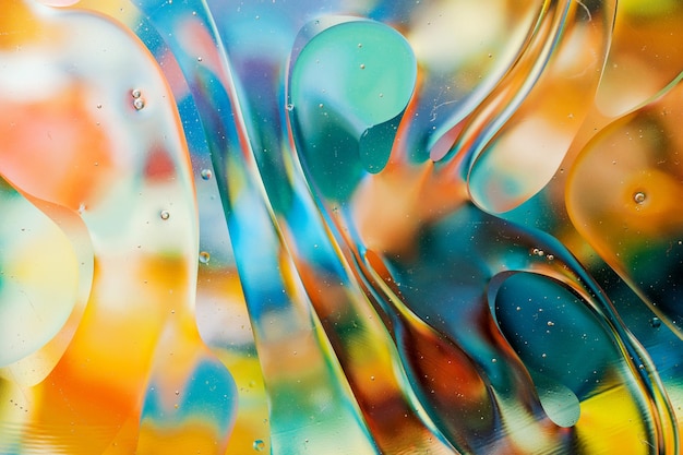 Zbliżenie ruchu kropel oleju na powierzchni wody Kolorowe abstrakcyjne tło makro kropli oleju na powierzchni wody