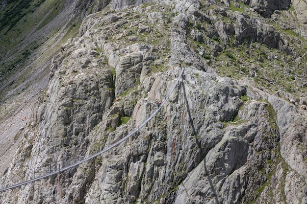 Zbliżenie sceny górskie, chodzić do Trift Bridge w parku narodowym Szwajcaria, Europa. Letni krajobraz, słoneczna pogoda, dramatyczne zachmurzone niebo i słoneczny dzień