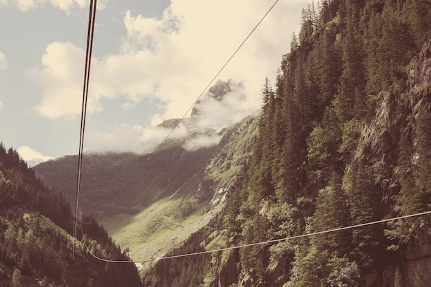 Zbliżenie sceny górskie, kolejka linowa do mostu Trift w parku narodowym Szwajcaria, Europa. Letni krajobraz, słoneczna pogoda, pochmurne niebo i słoneczny dzień