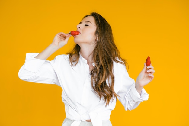 Zbliżenie sexy kobieta jedzenie świeżych truskawek Seksualne usta czerwona szminka Koncepcja zdrowej żywności