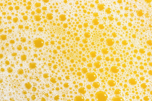 Zbliżenie soku pomarańczowego z pianki widok z góry plusk świeżego słodkiego soku owocowego z mango pomarańczowego