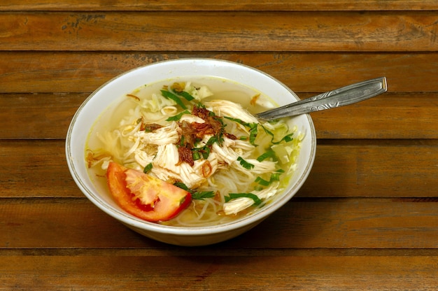 Zbliżenie Soto Ayam, indonezyjskiej pysznej tradycyjnej zupy z kurczaka na drewnianym stole