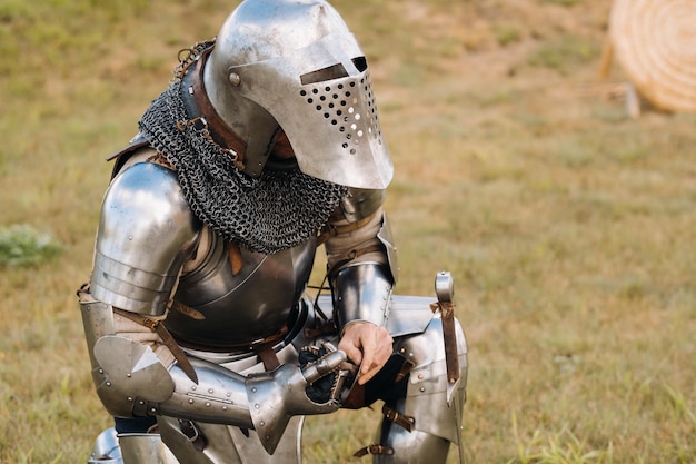 Zdjęcie zbliżenie średniowiecznego rycerza w zbroi przygotowującego się do bitwy