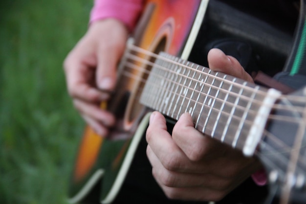 Zbliżenie środkowej części mężczyzny grającego na gitarze