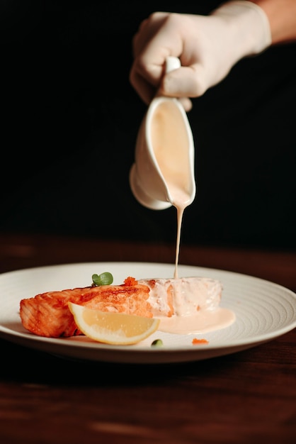 Zdjęcie zbliżenie, stek z łososia pieczony na białym talerzu, zwolnionym tempie
