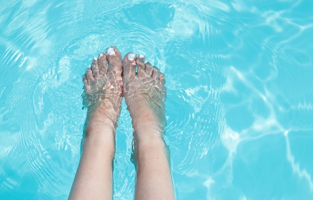 zbliżenie stóp dziewczyny w basenie watersummer słoneczny dzieńniebieski kolor watermockup miejsce na tekstwoman z