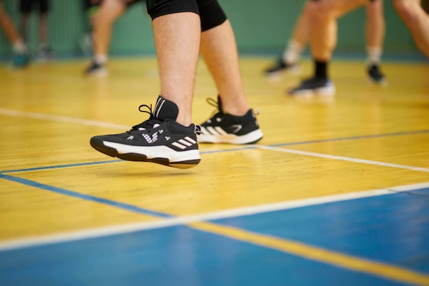 Zbliżenie stóp i nóg męskich siatkarzy w siatkówce na siłowni w hali