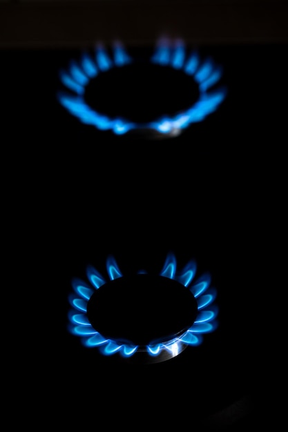 Zbliżenie strzał niebieskiego ognia z kuchni domowej Kuchenka gazowa Palnik gazowy Kuchenka gazowa z płonącymi płomieniami propanu Zasoby przemysłowe i koncepcja gospodarki