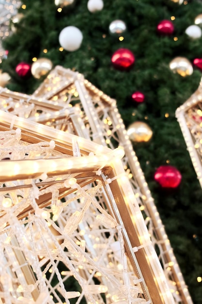 Zbliżenie świątecznej girlandy na tle udekorowanej choinki w centrum handlowym
