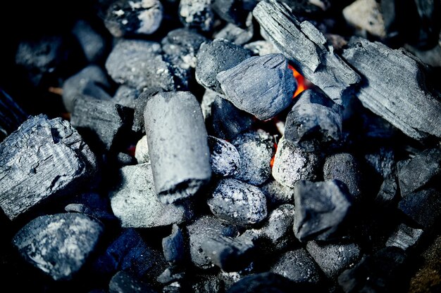 Zdjęcie zbliżenie świecącego węgla w metalowym grillie w letni dzień w ogrodzie