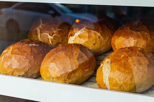 Zbliżenie świeżego białego chleba w rolkach stoi w równych rzędach w piekarni