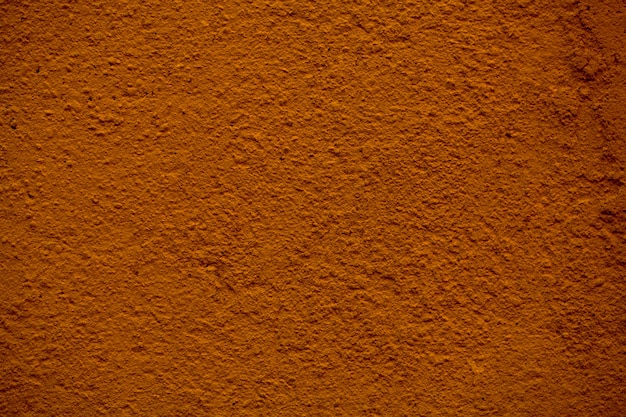 Zbliżenie szczegółów tekstury malowanej brązowej ściany z szorstkim wykończeniem tynku