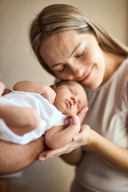 Zbliżenie szczęśliwa młoda matka trzyma noworodka