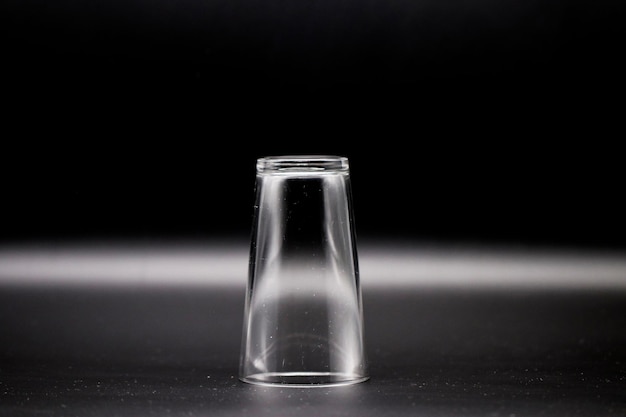 Zdjęcie zbliżenie szklanej butelki na stole na czarnym tle