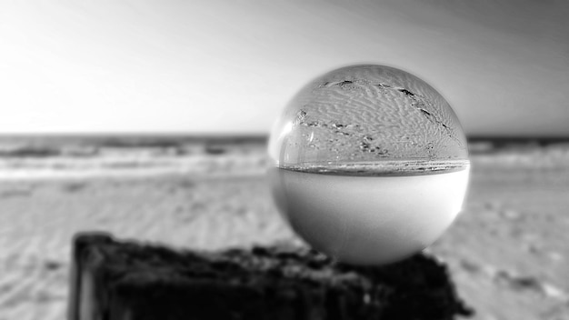 Zdjęcie zbliżenie szklanki wody na plaży