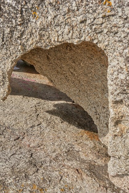 Zbliżenie szorstkiej skały z głębokimi pęknięciami, otworami i szczelinami od ciepła wiatru lub erozji wodnej z globalnego ocieplenia lub zmiany klimatu Szczegóły tekstury i tło skał osadowych lub granitu na zewnątrz