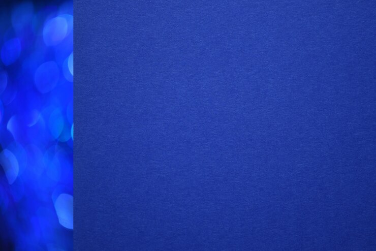 Zbliżenie textured błękitnego papieru z bożych narodzeń błękitną bokeh linią po lewej stronie.