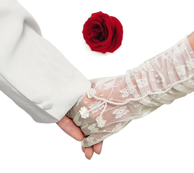 Zbliżenie trzymając się za ręce z czerwoną różą