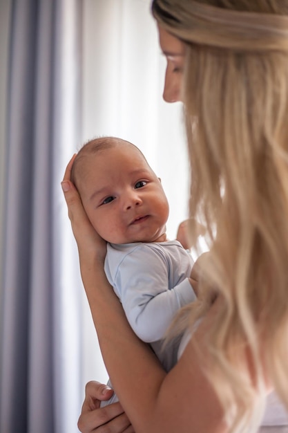 Zbliżenie uśmiechniętej matki z uroczym dzieckiem w domu