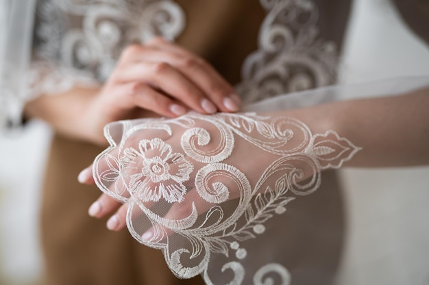 Zbliżenie welonu ślubnego z haftowanym wzorem na dłoni