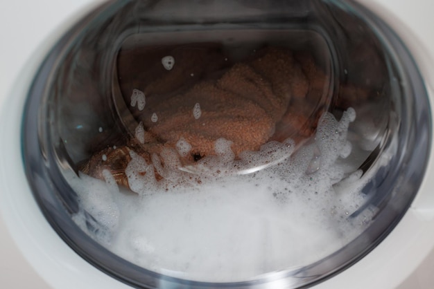 Zbliżenie wirującego bębna pralka biała pralka myje brudne kolorowe ubrania