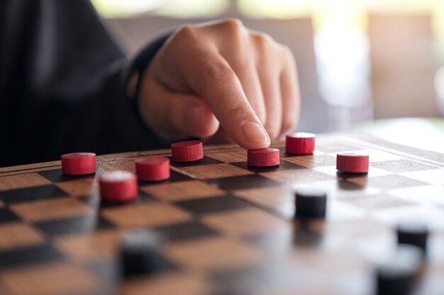 Zbliżenie wizerunek ludzie bawić się warcaby w chessboard i poruszający
