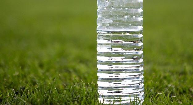 Zdjęcie zbliżenie wody w butelce na trawie