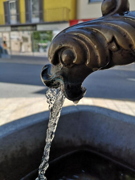 Zdjęcie zbliżenie wody z kranu w mieście