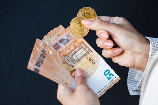 Zbliżenie womans ręce trzymając złote monety kryptowaluty i banknotów euro ubrany w białą kurtkę Pojęcie oszczędności i wynagrodzeń w gotówce