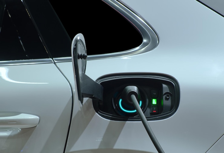 Zdjęcie zbliżenie wtyczki elektrycznej maszyny do ładowania podłączonej do gniazda samochodu elektrycznego do ładowania baterii