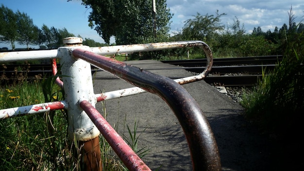 Zdjęcie zbliżenie zardzewiałego metalowego ogrodzenia na polu