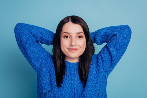 Zbliżenie zdjęcie portret pięknej, wesołej, uroczej, atrakcyjnej damy, która odpoczywa, relaksuje ręce za głową na białym tle na niebieskim tle