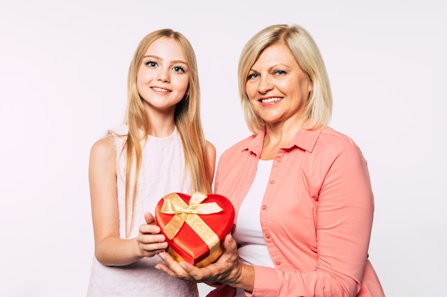 Zdjęcie zbliżenie zdjęcie szczęśliwej babci i wnuczki w dobrym i zabawnym nastroju na białym tle razem. kocham moją babcię. święta i uroczystości rodzinne