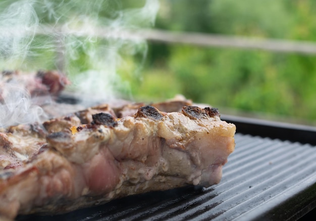 Zdjęcie zbliżenie żeberek wieprzowych grillowanych w ogrodzie