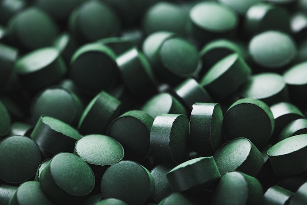 Zbliżenie zielonych tabletek spiruliny organicznej jako makro tekstury tła na pełnym ekranie