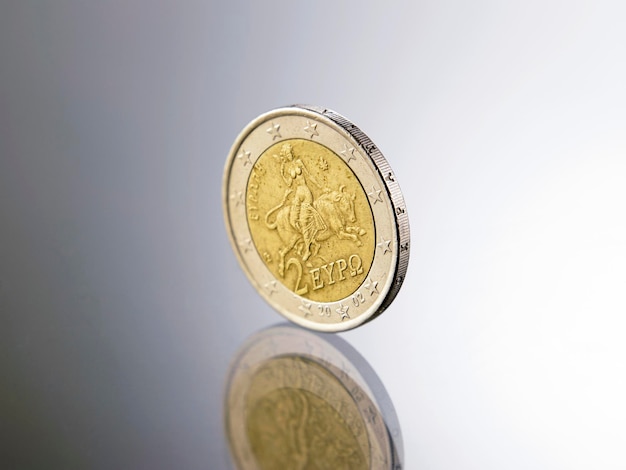 Zdjęcie zbliżenie złotej monety na szarym tle
