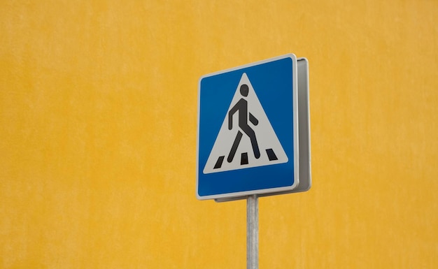 Zdjęcie zbliżenie znaku drogowego na żółtej ścianie
